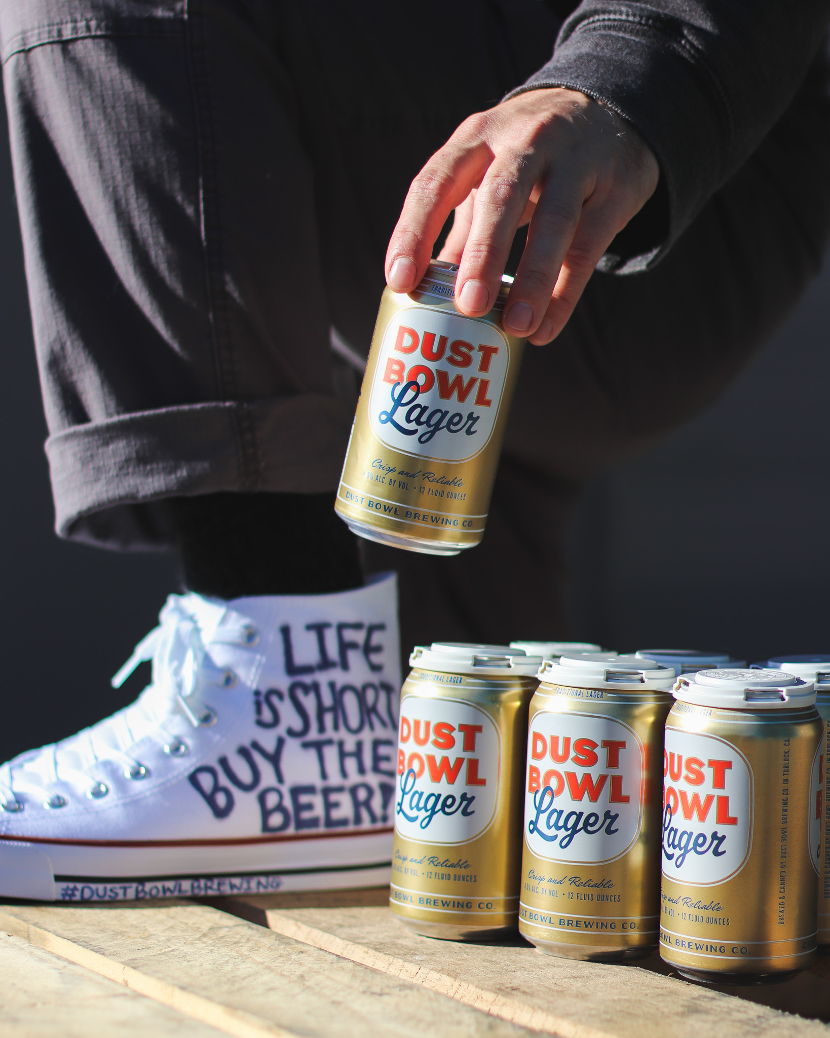 Dust Bowl Lager cans with white converse in background